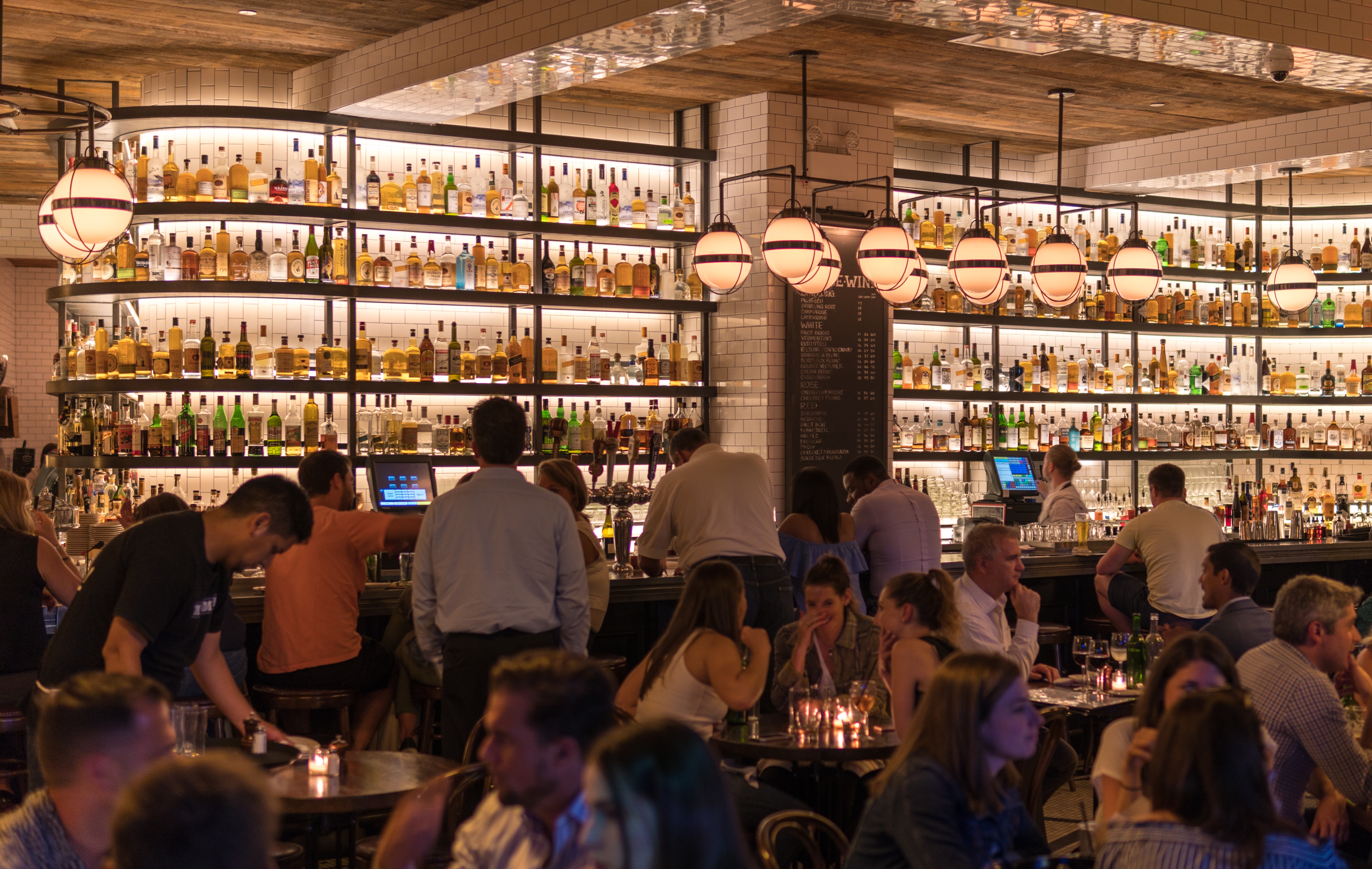 crowded restaurant with pendant lights and reflecting ceiling